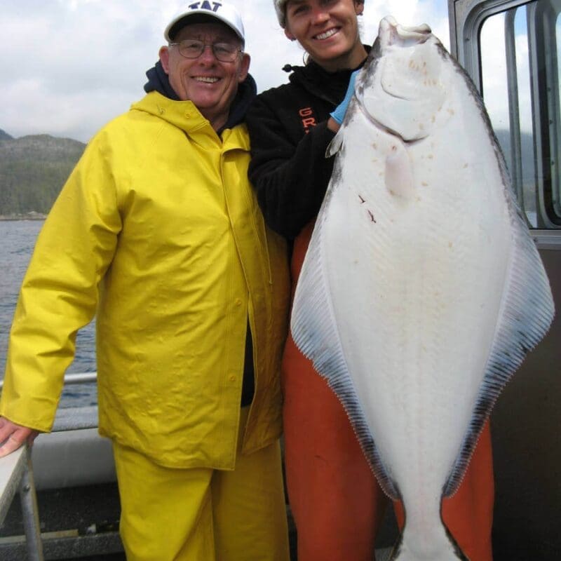 Angling Unlimited guest and crew member hold a halibut