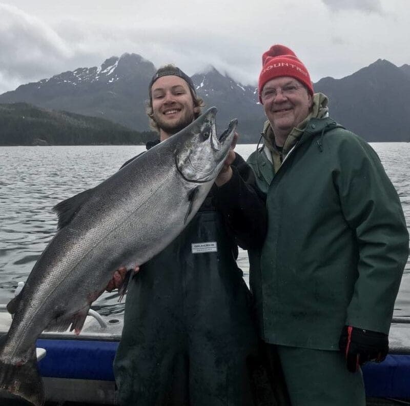 Angling Unlimited guest poses with crew member with a king salmon
