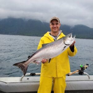 Man stands holding a salmon