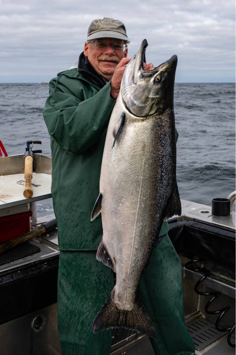 Angling Unlimited guest holds up a king salmon
