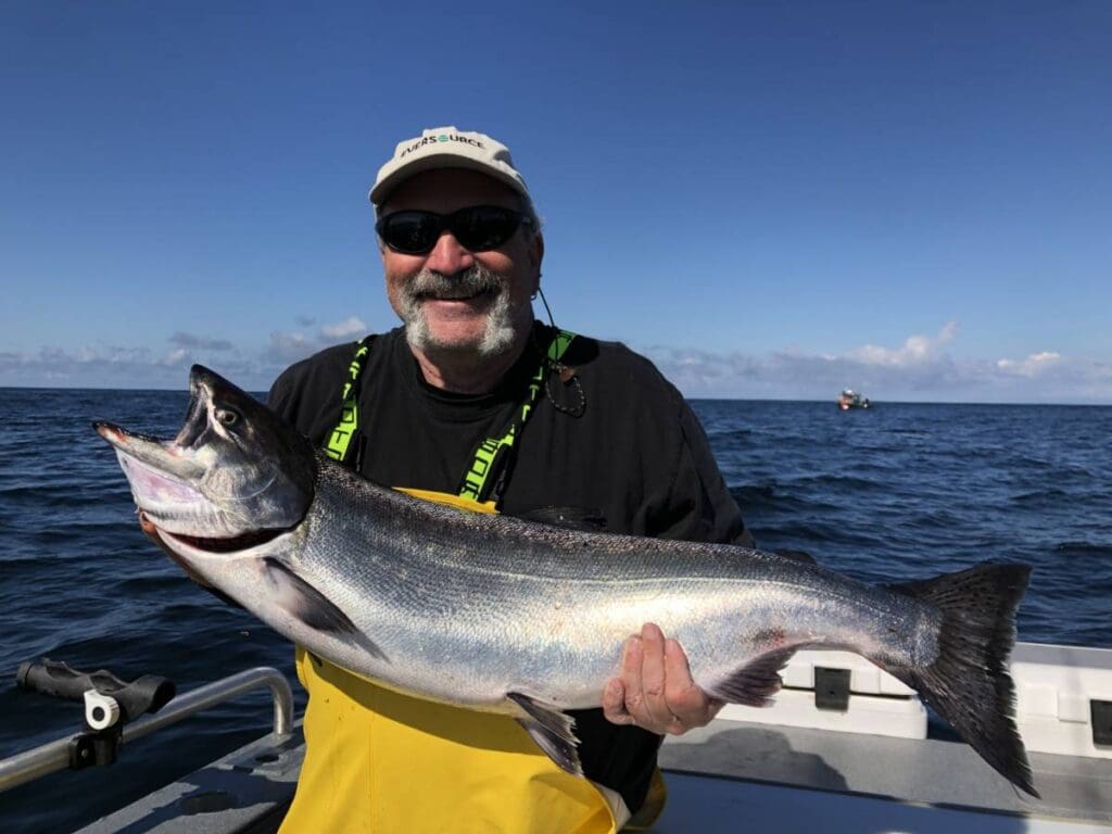 Angling Unlimited guest holds up a salmon caught in Sitka