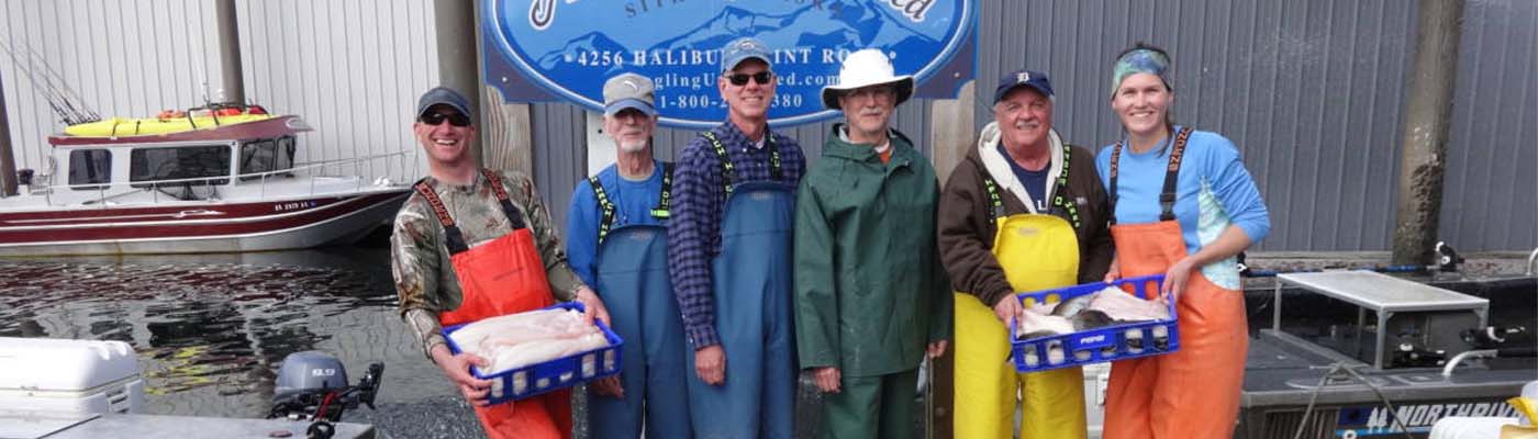 Angling Unlimited crew members pose with guests holding filleted fish