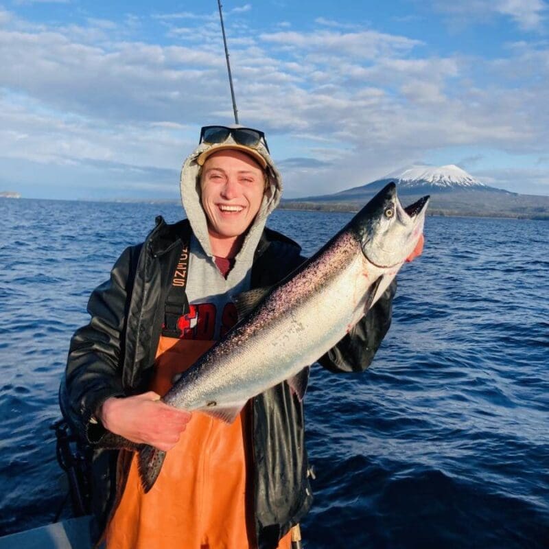 Angling Unlimited crew member Wystan Duhn holds a salmon in Sitka, Alaska