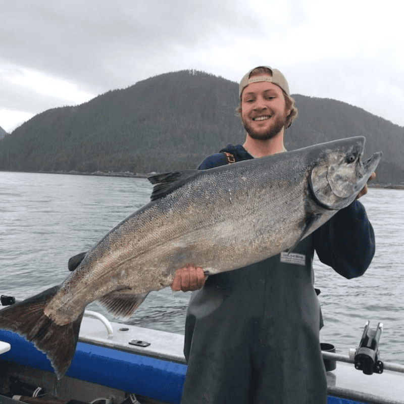 Angling Unlimited crew member Jack Barnick holds a fish on a boat in Sitka, Alaska
