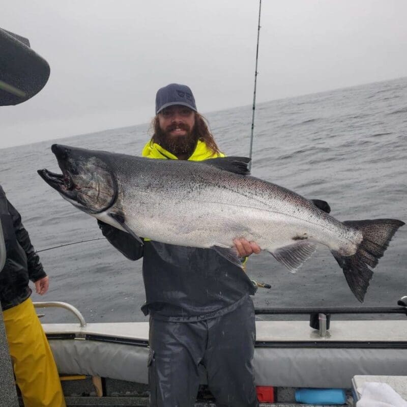 Angling Unlimited crew member Ryan Leverington holds a salmon in Sitka, Alaska