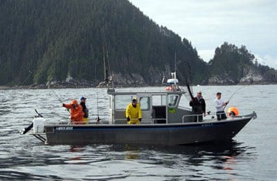 Angling Unlimited fishing boat in the water with people fishing off of it in Sitka, Alaska